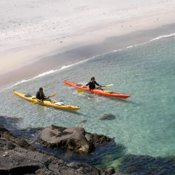 sea kayakers leaving the beach