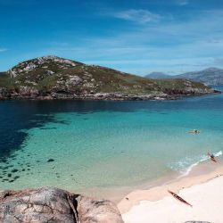 white sand beach, mountains and kayaks