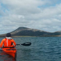 paddler enjoying sea loch with mountain view